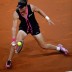 Sam Stosur slides on the indoor red clay of Porsche Arena to retrieve a Kerber shot; Getty Images