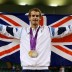 A national hero, Andy Murray of Great Britain poses with his gold and silver medals while wrapped in the Union Jack flag at the conclusion of the London 2012 Olympic Games tennis event at the All England Club; Getty Images