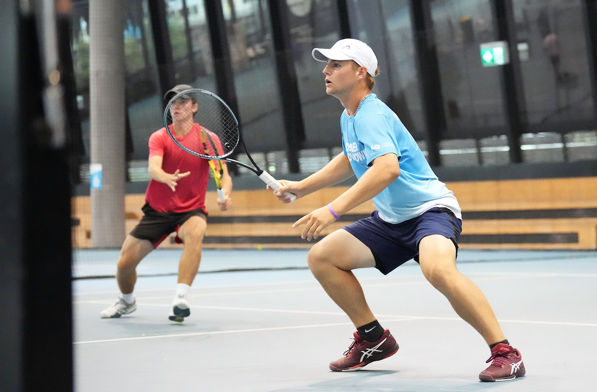 2 men playing doubles tennis
