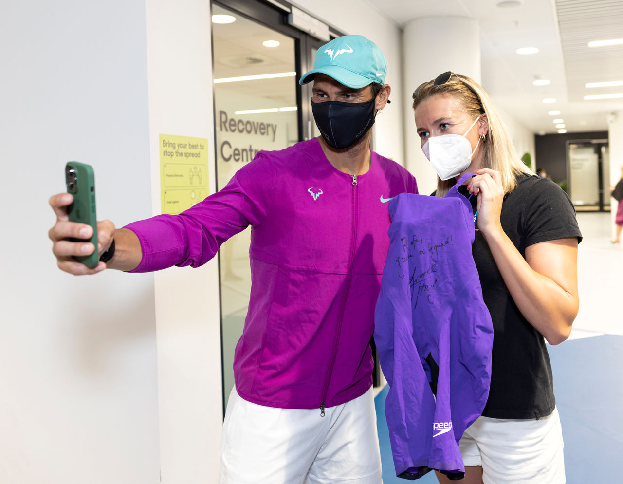 Rafael NADAL (ESP) takes a selfie with Ariarne Titmus who gave him a version of the swimsuit she wore in the Olympics, at the Australian Open at Melbourne Park in Melbourne on Sunday, January 23, 2022. MANDATORY PHOTO CREDIT FIONA HAMILTON/TENNIS AUSTRALIA