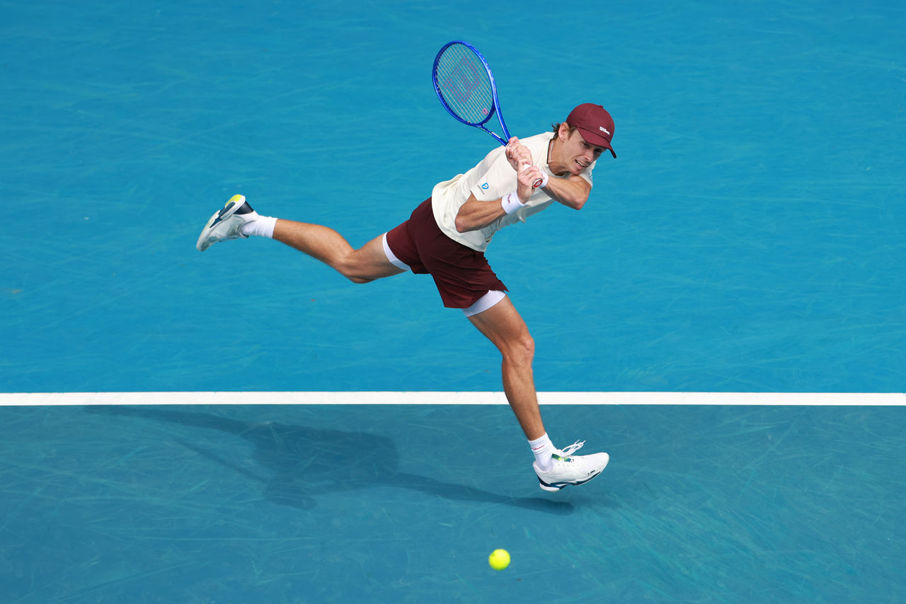 MELBOURNE, AUSTRALIA - JANUARY 19: Alex de Minaur of Australia plays a backhand against Mackenzie McDonald of the United States in the Men's Singles First Round during day two of the 2026 Australian Open at Melbourne Park on January 19, 2026 in Melbourne, Australia. (Photo by Lintao Zhang/Getty Images)