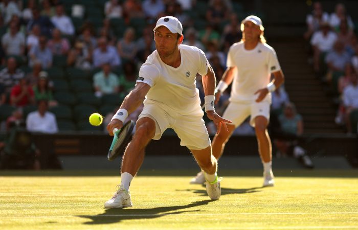 LONDON, ENGLAND - JULY 09: Matthew Ebden of Australia plays a backhand as partner Max Purcell of Australia looks on against Nikola Mektic of Croatia and Mate Pavic of Croatia during their Men's Doubles Final match on day thirteen of The Championships Wimbledon 2022 at All England Lawn Tennis and Croquet Club on July 09, 2022 in London, England. (Photo by Julian Finney/Getty Images)