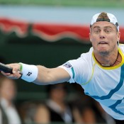 Lleyton Hewitt stretches his body, and his face, in an effort to reach the ball.
