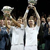 Wildcard pairing Jonathan Marray of Great Britain (R) and Frederik Nielsen of Denmark lift their winners trophies after capturing the gentlemen's doubles title at Wimbledon; Getty Images