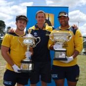 ACT Brumbies Zach Holmes (L) and Scott Sio (R) and Backs Coach and former Wallaby Steve Larkham pose with the Australian Open trophies in Canberra