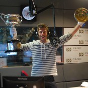 ABC 976 radio host Ryk Goddard poses with the Australian Open trophies in the studio during the breakfast radio show in Hobart; Tennis Australia