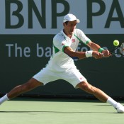 Novak Djokovic employs his trademark split stretch when hitting a backhand against Juan Martin del Potro during their men's semifinal on Day 11 at the BNP Paribas Open at Indian Wells Tennis Garden; Getty Images