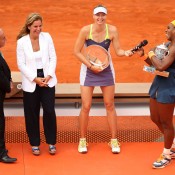Serena Williams (R) shares a joke with Maria Sharapova (second from left) during the French Open women's singles trophy ceremony as Francesco Ricci Bitti (L) and Arantxa Sanchez Vicario look on; Getty Images
