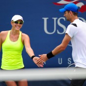 Anastasia Rodionova (L) of Australia taps hands with her partner Mariusz Fyrstenberg of Poland during their mixed doubles 6-3 2-6 [10-8] first round loss to Kveta Peschke of Czech Republic and Marcin Matkowski of Poland on Day 3 of the US Open; Getty Images