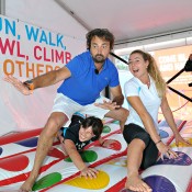 MELBOURNE, AUSTRALIA - JANUARY 22: Henri Leconte of France poses with Hockey player Claire Messent and Surfer Nikki van Dijk  (r) during a game of giant inflatable twister on Grand Slam Oval during day 10 of the 2014 Australian Open at Melbourne Park on January 22, 2014 in Melbourne, Australia.  (Photo by Vince Caligiuri/Getty Images)