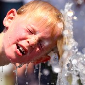 MELBOURNE, AUSTRALIA - JANUARY 16:  A child plays in the water fountain in the heat during day four of the 2014 Australian Open at Melbourne Park on January 16, 2014 in Melbourne, Australia.  (Photo by Ryan Pierse/Getty Images)