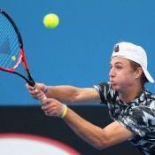 Omar Jasika of Australia plays a backhand in his qualifying match against Mathias Bourgue of France for 2015 Australian Open at Melbourne Park on January 14, 2015 in Melbourne, Australia.  (Photo by Robert Prezioso/Getty Images)