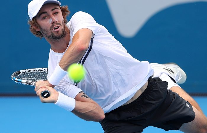 Jordan Thompson plays a backhand in the searing Sydney heat.