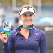 Arina Rodionova celebrates her victory at the AO Play-off with her player accreditation pass for Australian Open 2020. (photo: Elizabeth Bai/Tennis Australia)