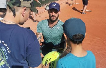 Heath Davidson signs autographs for fans at Roland Garros.